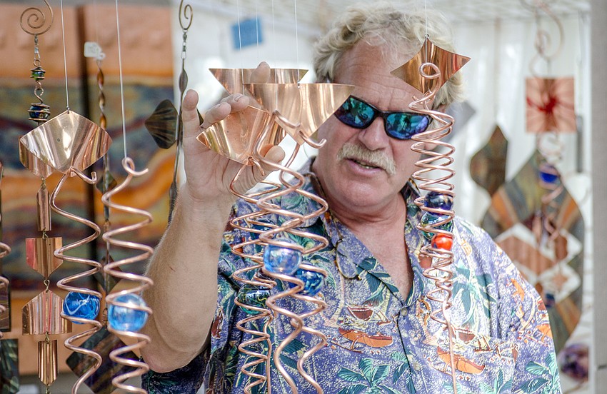 Robert Boyce of Shooting Star unique copper creations shows his products to festivalgoers.