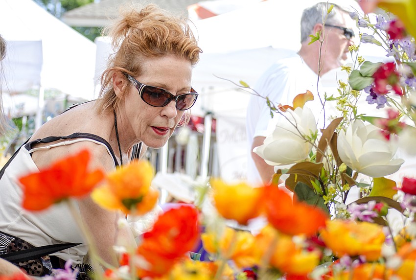 Donna Zanardi peruses flower arrangements at Siesta Fiesta