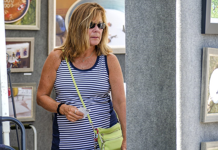 Paula Sullivan peruses photos at the Siesta Fiesta.