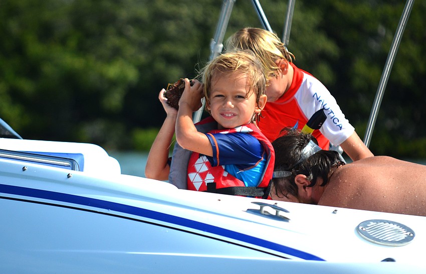 Oliver Long, 4, shows off a sea urchin him and his brother found before releasing it back in the water.