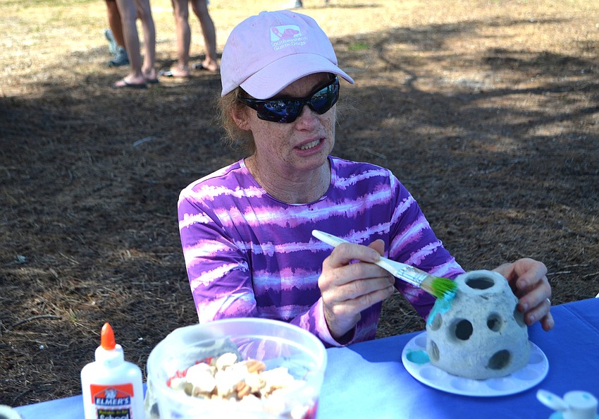 Kim Walsh paints a coral reef replica at the Seagrass Survey on April 29.