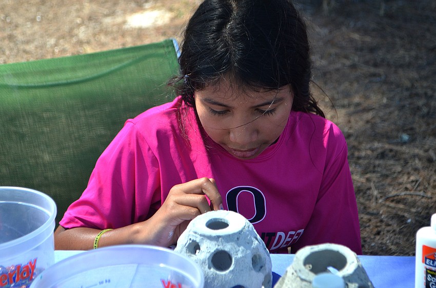Maddie Walsh, 9, paints a coral reef replica at the Seagrass Survey on April 29.