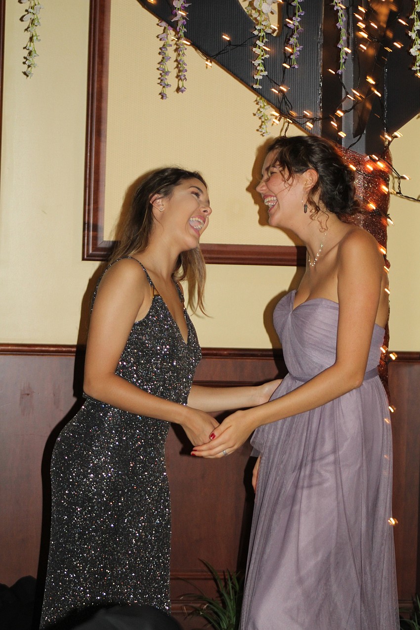 Braden River High School senior Gabriela Sullivan and junior Lily King share laughs during their high school prom.