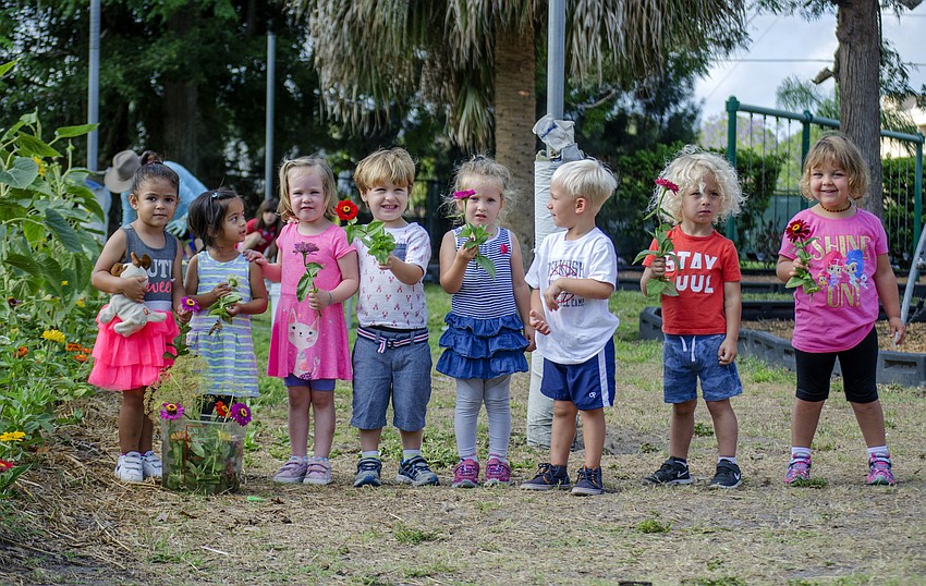 Hershorin Schiff Community Day School preschoolers posed with flowers they picked from the Papa Ed and Mimi Rosenthal Organic Kibbutz Sustainability Garden and Outdoor Classroom.