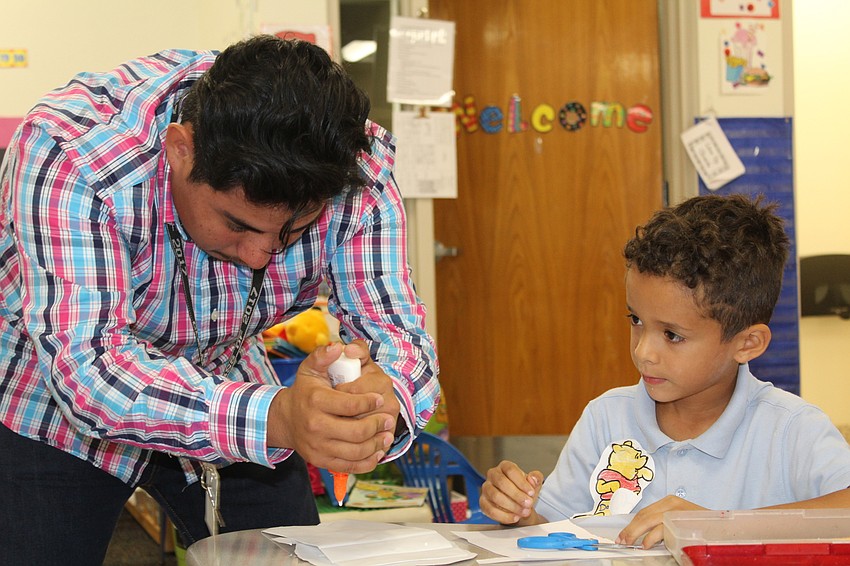 Lakewood Ranch High School senior Guillermo Sanchez and Bashaw Elementary School kindergartner Damian Gutierrez work together on their paper puppet.