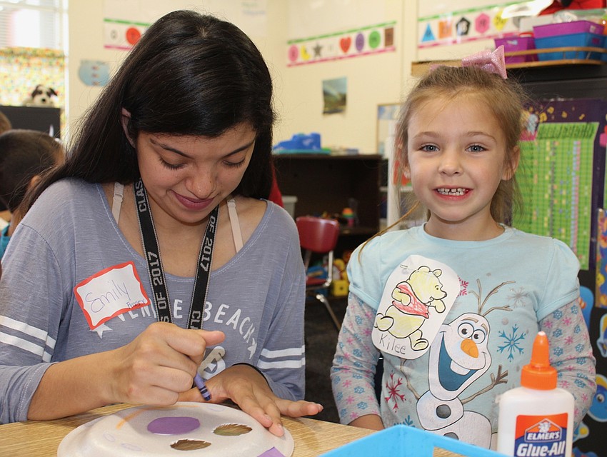 Lakewood Ranch High School senior Emily Zavala helps Bashaw Elementary School pre-K student Kilee Hulley with a craft.