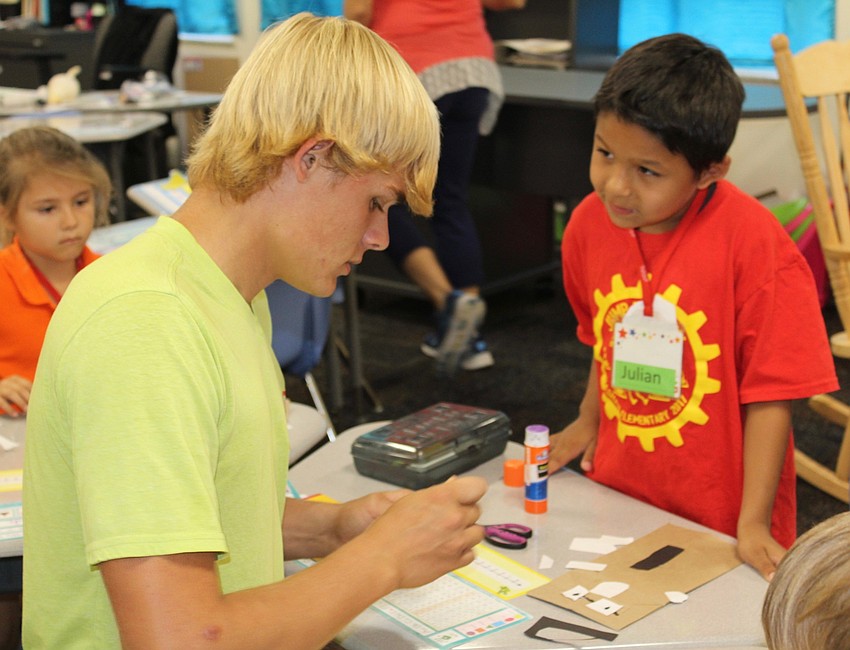 Lakewood Ranch High School senior Joshua Crowe works on a craft with Bashaw Elementary School kindergartner Julian Trueblood.