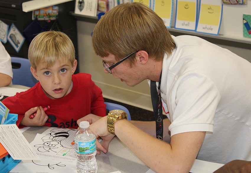 Bashaw Elementary School kindergartner Tyson Kelsey works on a crossword puzzle with Lakewood Ranch High School senior Chandler Jurek.