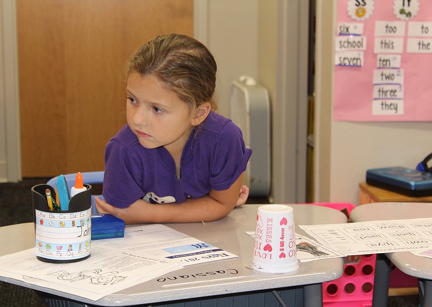 Bashaw Elementary School second grader Cayleigh Greer listens closely as Lakewood Ranch High School seniors read their storybook.