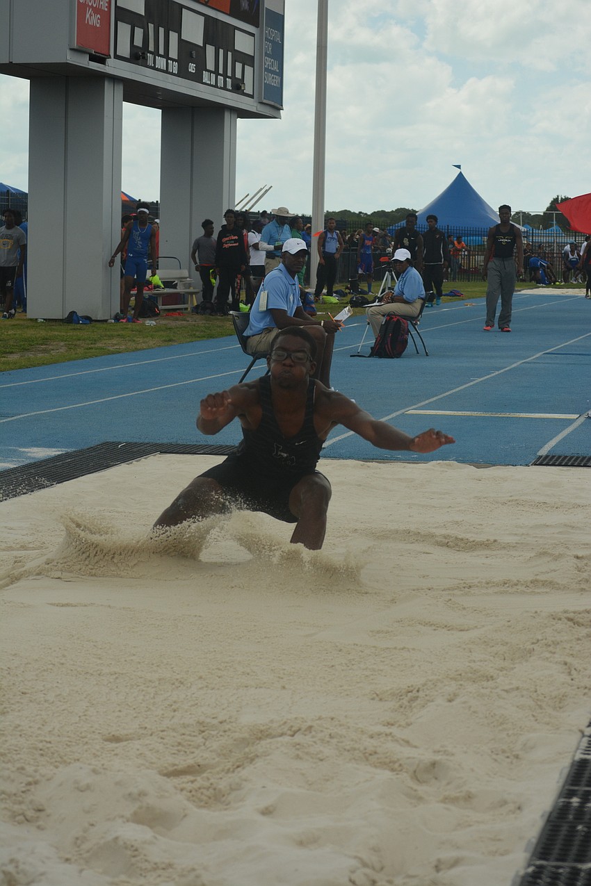 Lakewood Ranch'  s Harry Barthelemy kicks up sand in the Clas 4 boys long jump.