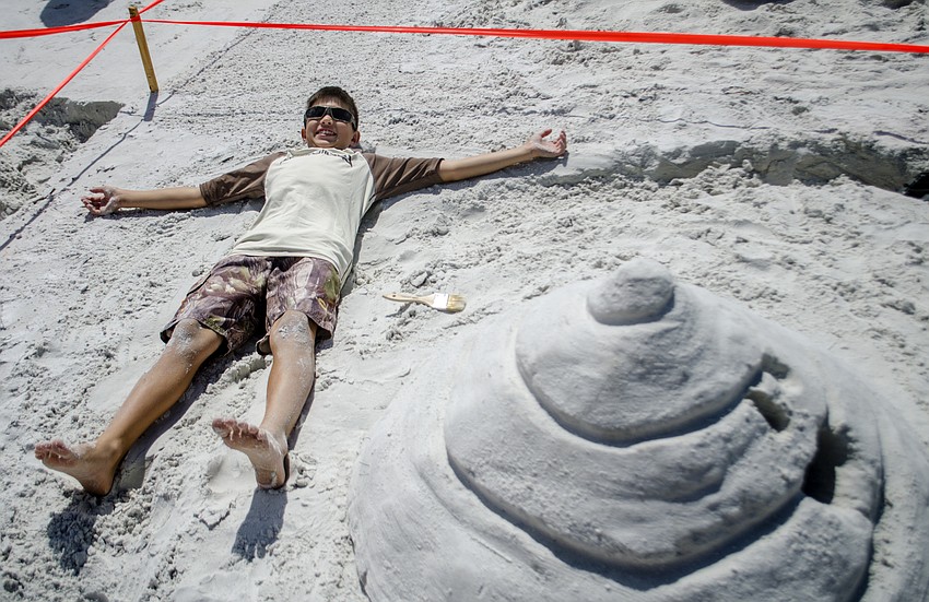 Cole Loo lies down next to his sculpture called Emoji.