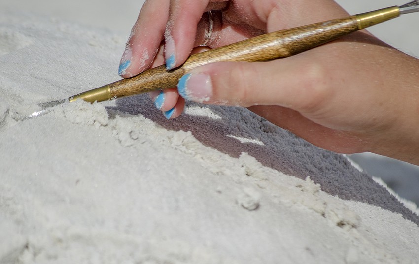 Lillian Loo carves in the details to her sculpture called Tank the Turtle.