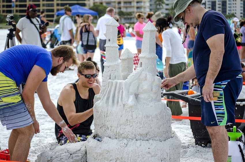 Alec, Justin and Dave Muklewicz work on their entry in the 45th annual Amateur Sand Sculpture Contest.