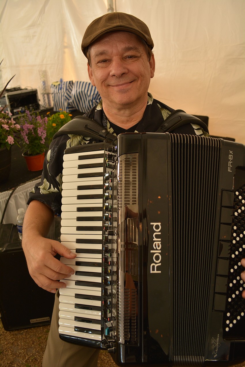 Chuck Henry, of Chuck Henry and Music, plays accordion before dinner for guests.