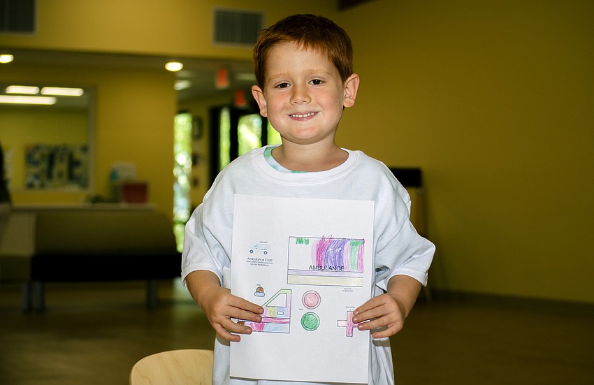 Woody Bryant poses with the picture he colored for first responders.