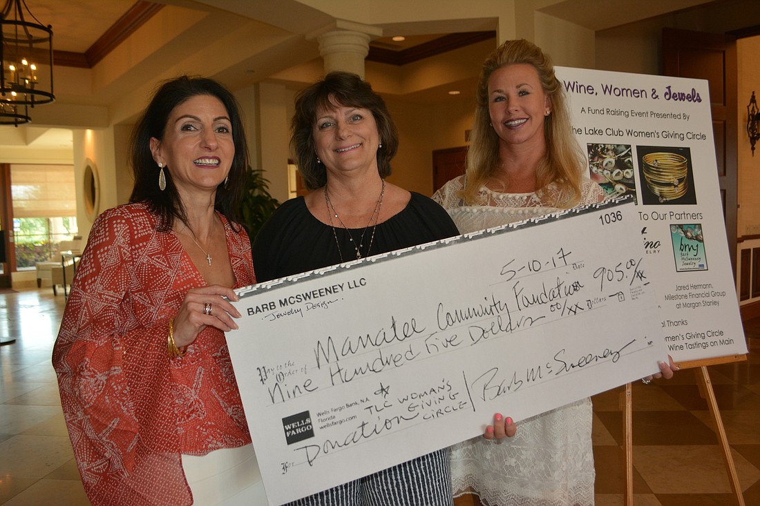 Babara Najmy, Barb McSweeney and Traci Smullen show off a check for $905 that McSweeney donated to the Lake Club Women&#39;     s Giving Circle off sales of her jewelry at Wine, Women & Jewels.