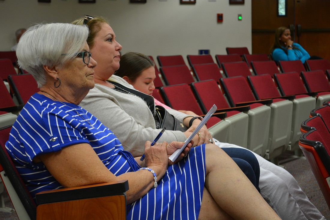 Donna King, front, and her daughter, Sharon Cadet (center) and granddaughter Abby Tran (behind) listen at the May 11 Planning Commission meeting about a new development near their homes.
