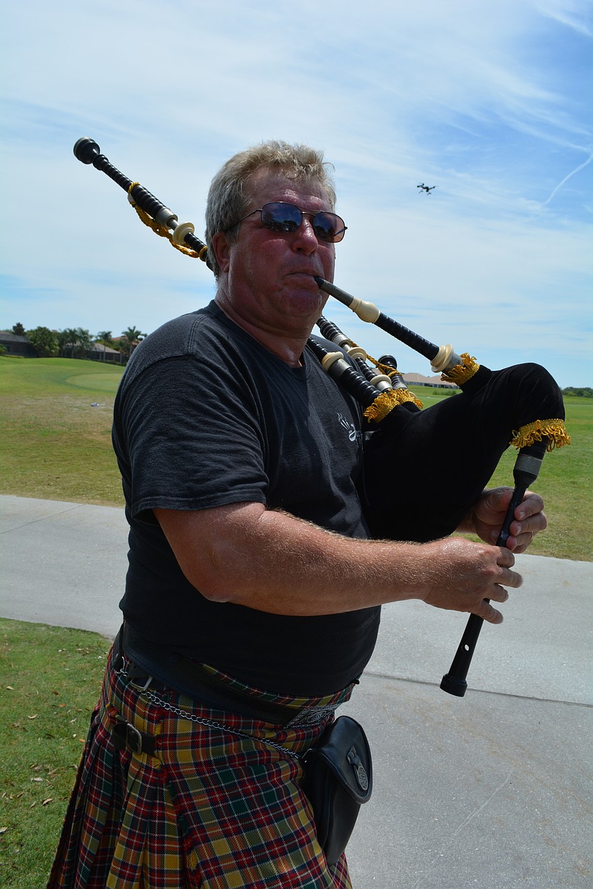 Gary Reinstrom, of Jacobites Band, leads the golf procession with songs.
