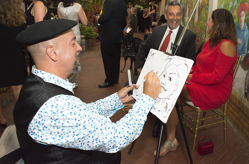 Michael James White creates a caricature portrait of Jay and Amy Grewal