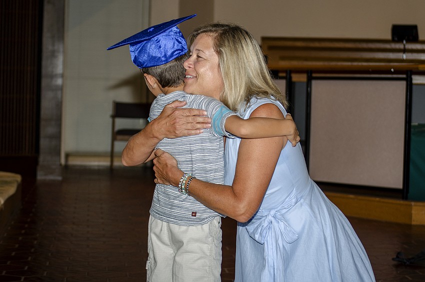 Carol Mohan hugs David Cook after he was introduced at the St. Boniface Preschool graduation ceremony.