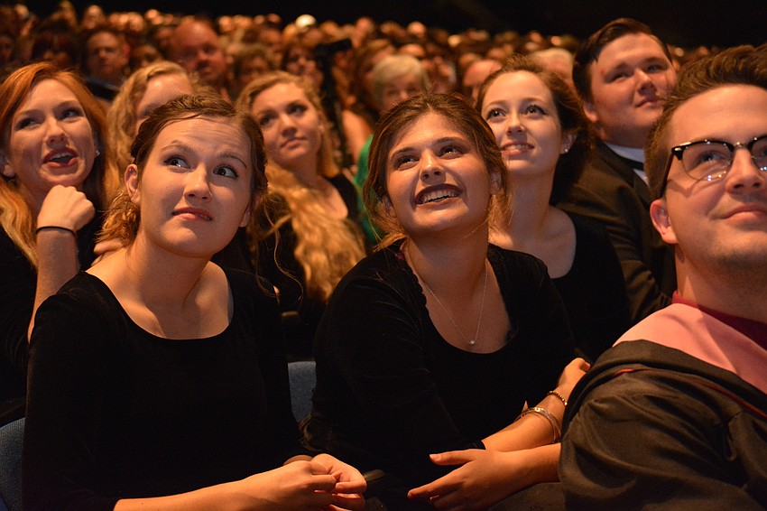 Braden River Rhapsody singer Kristina Vasiljevic, center, smiles while watching a photo video of seniors. To her left is Sydney Dowling.