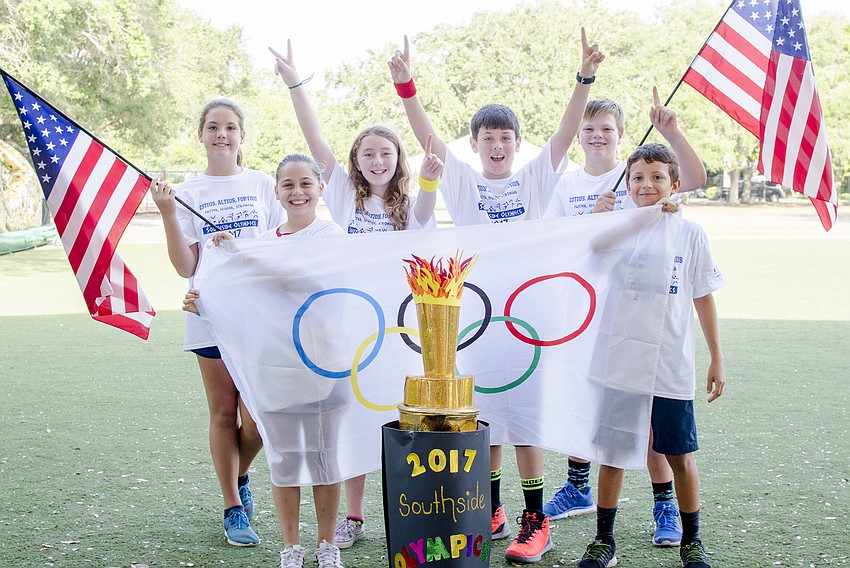 Luci Wicks, Samantha Fineman, Sophia Clarke, Matthew Knoll, William Mathes and Max Brunelle pose in front of the Southside Olympics torch.