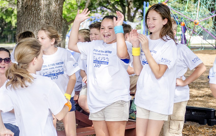Izzy Ferreira and Kayla Fritz cheer on their fellow students as they jump hurdles.