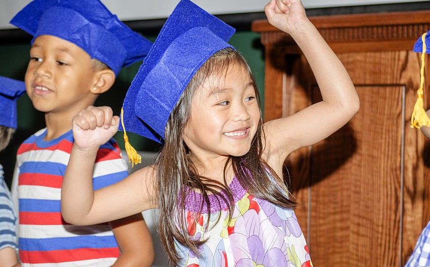 Carissa Coquinco cheers after finishing a song during the First Presbyterian Preschool graduation ceremony.