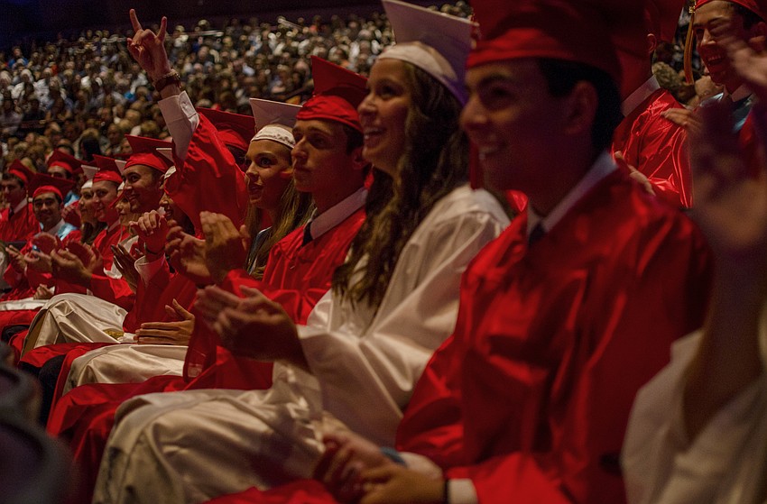 Students cheer as Senior Class President Shane Black takes a seat after giving the invocation.