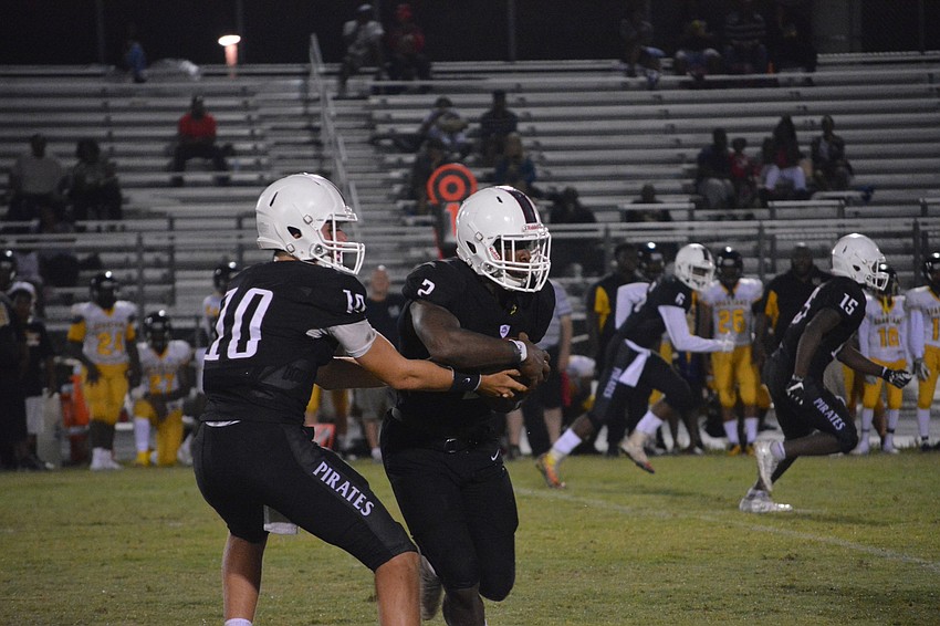 Bryan Gagg hands the ball to Deshaun Fenwick.