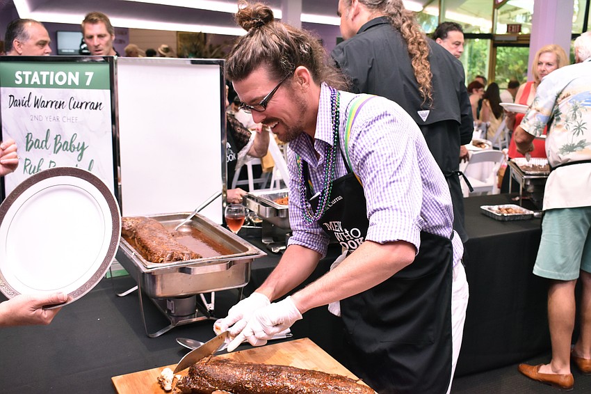 David Warren Curran cuts bad baby rub-roasted pork loin for guests at Men Who Cook & Brew on May 21 at Mattison’s Bayside at Van Wezel Performing Arts Hall.