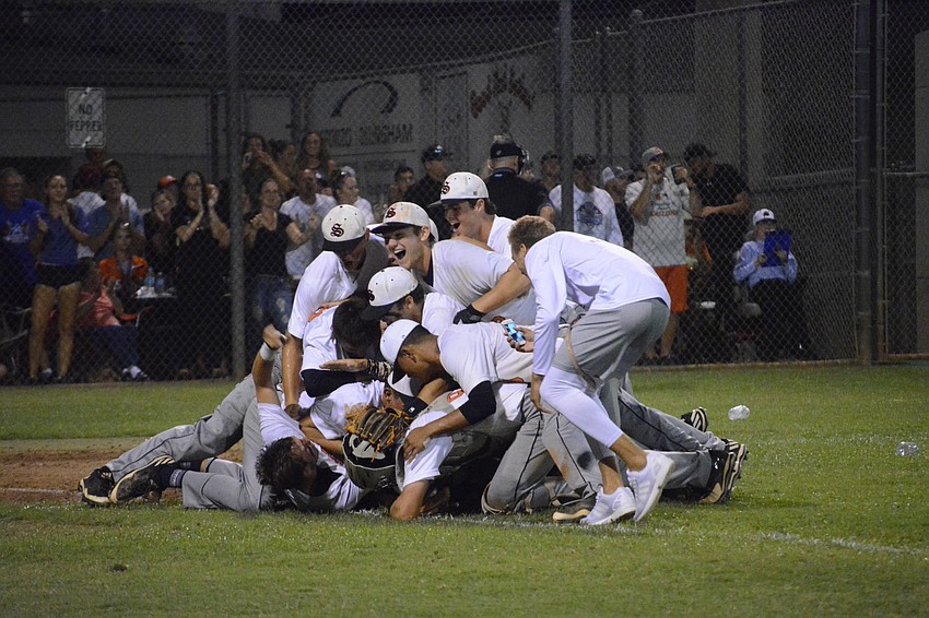The Sailors form a dog pile on the infield grass.