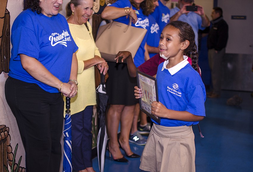 Boys and Girls Club participant Tatiana shows off the thank you card the children made for Leadership Sarasota County members.