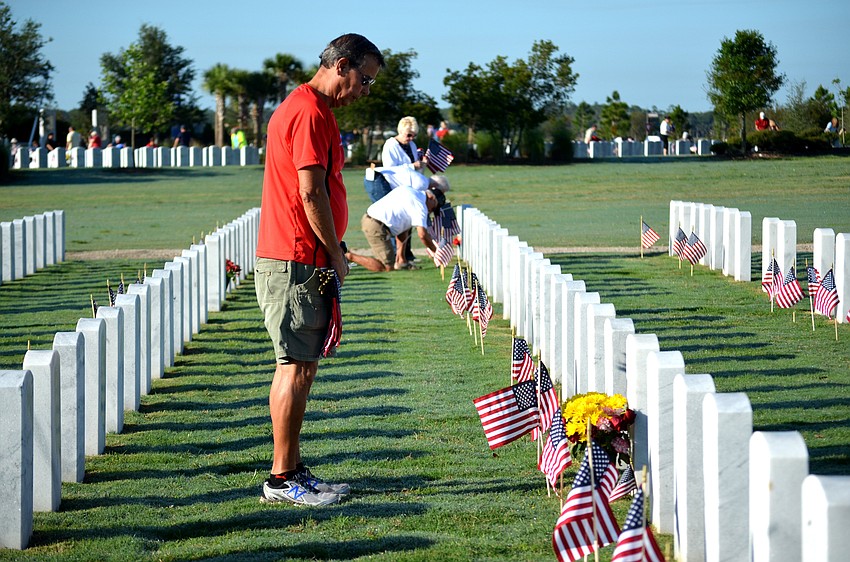 Richard Stufft takes a moment at the gravesites where he placed flags.