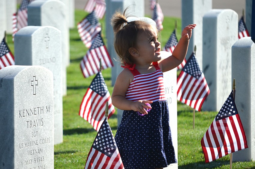 Aubrey Savoca waits to drop rose petals around gravesites.