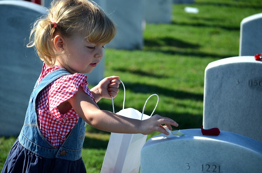 Stella Tessier places rose petals on gravesites.