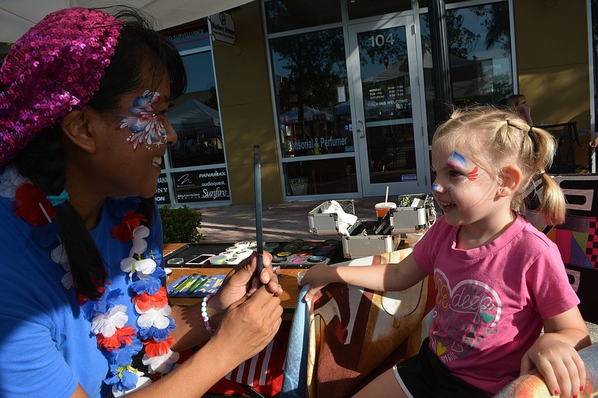 Akiko Campbell shows Bradenton'   s Alivia Baker, 5, her face after being painted.