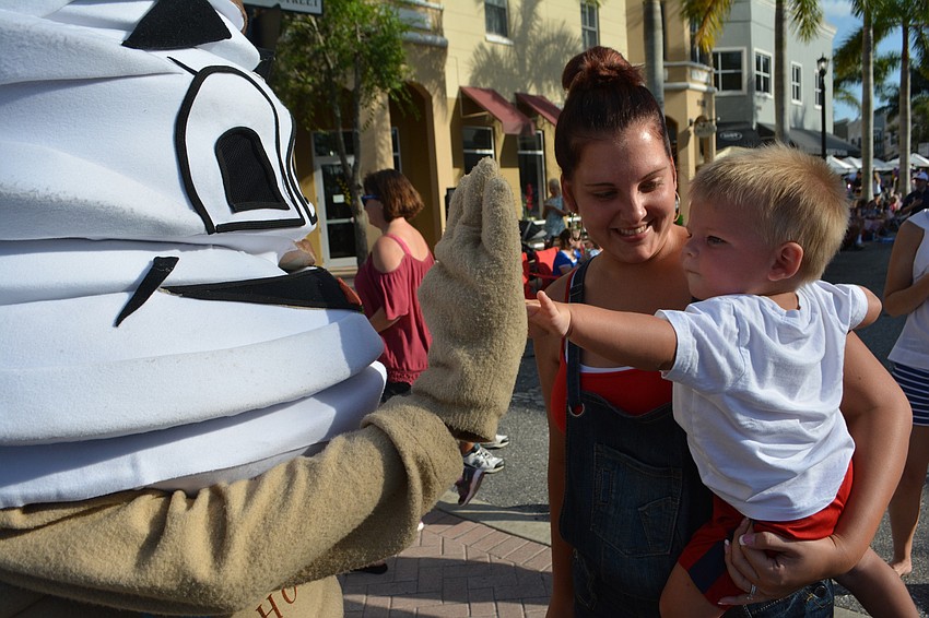 Jakob Cunnien, an 18-month-old from Bradenton, is held by his mom, Alexa, as he gives the Daisy D'   Lites mascot a high-five.