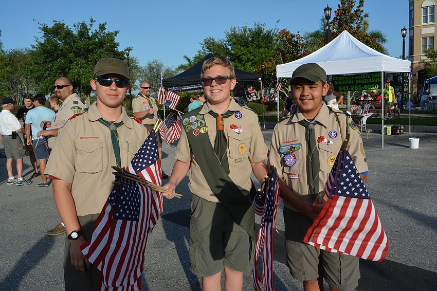 Samuel Yunker, Bryce Jensen and Francisco Cedillo, Boys Scouts of Troop 89 (Christ Presbyterian Church), hand out flags at the parade.