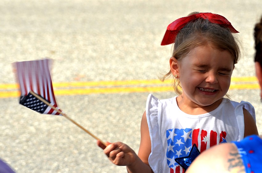 Zayla Hull waves her American flag before the parade begins.
