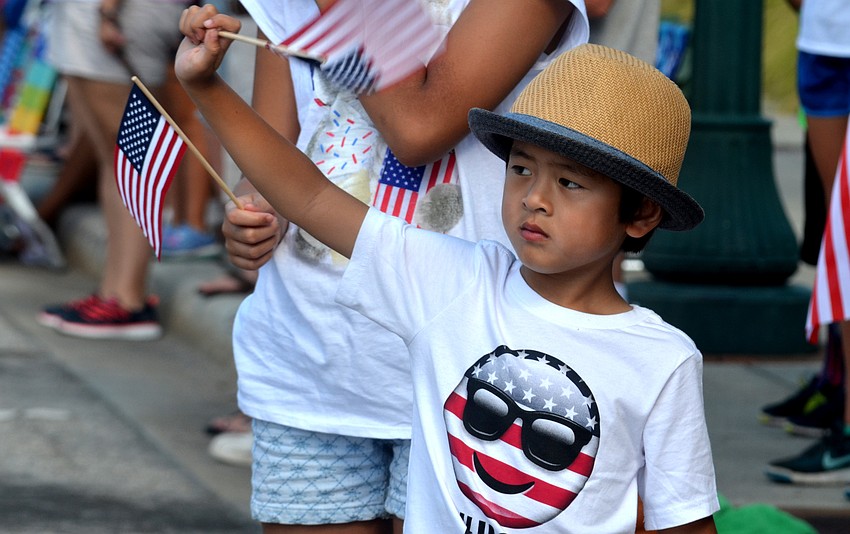 Quincy Tran waves his flag at the passing parade.