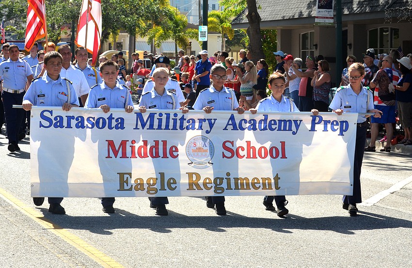 Members of the Eagle Regiment of the Sarasota Military Academy Prep School carry a banner down Main Street.