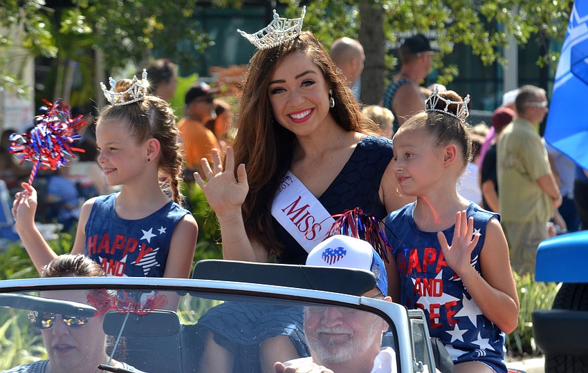 Miss Orange County, Lauren Nielsen, who grew up in Sarasota, waves alongside Lilly Wheeler and Madison Bogue, Florida Sunshine Princesses