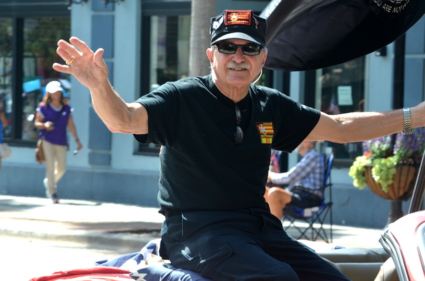 Jim Vendola, of the Vietnam Brotherhood, waves to the crowd.