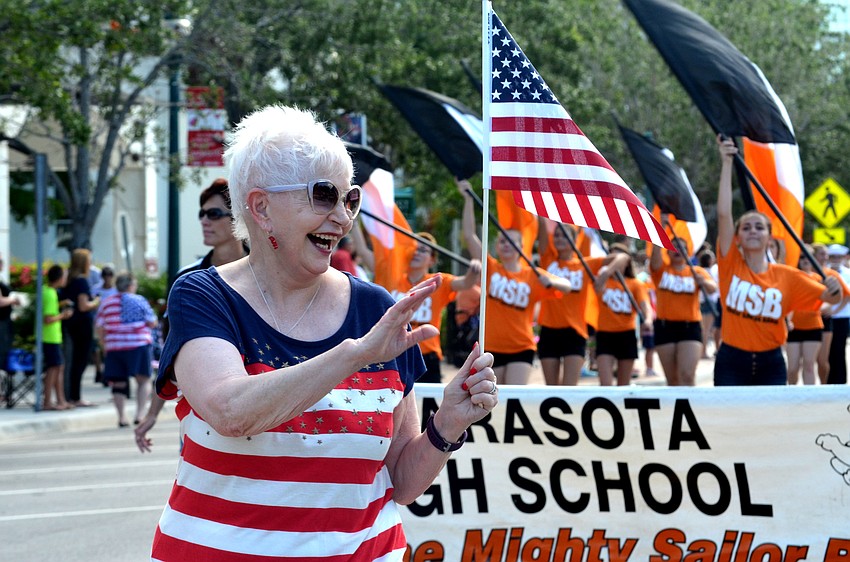 Sarasota County School Board Chairwoman Caroline Zucker waves to the crowd as she walks down Main Street.