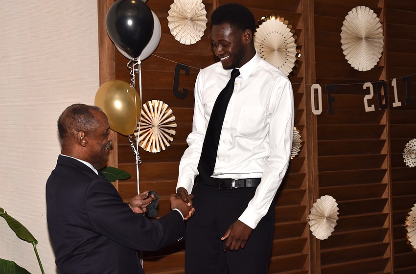 Booker High School graduate Odane Lennox, an incoming student of the Gator Engineering Program of SCF & UF,  shakes hands with Ted Downing  during Celebration of Hope on May 31 at The Francis.