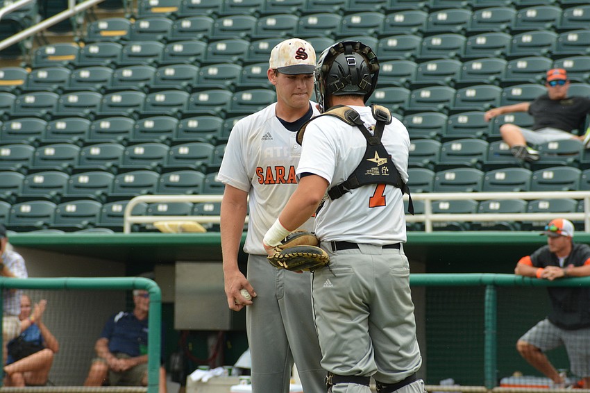 Brooks Larson talks with catcher Cole Madden on the mound.