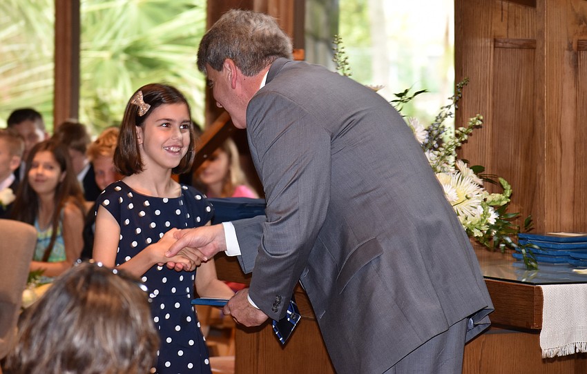Darcey Skelton shakes hands with Head of School David Mahler after winning the Citizenship Award at the Out-of-Door Academy Lower School Graduation on June 2 at Siesta Key Chapel.