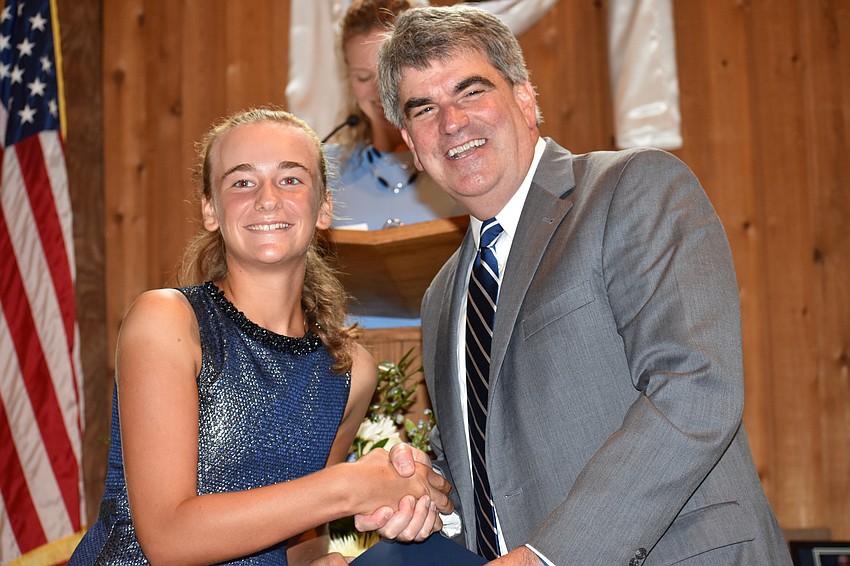 Ava Grace Krug shakes hands with Head of School David Mahler after getting her diploma at the Out-of-Door Academy Lower School Graduation on June 2 at Siesta Key Chapel.