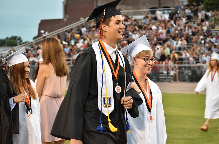 Students enter arm in arm during Sarasota High School graduation at Cleland Stadium at Ihrig Field.
